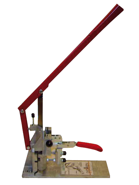 Eine manuelle Hebelpresse mit langem roten Hebel und kleinem rotem Griff, montiert auf einer Metallbasis, verwendet zum Stanzen oder Pressen kleiner Bauteile. Die Presse verfügt über einen schwenkbaren Arm, verstellbare Komponenten und eine rechteckige Bodenplatte mit aufgedruckter Anleitung.