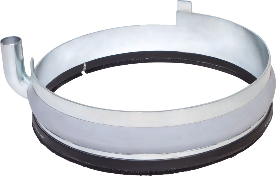 Nahaufnahme eines runden Metallanschlussrings oder Rohrkupplungsbands aus verzinktem Stahl mit innenliegender schwarzer Gummidichtung und borstenartigem Dichtungsstreifen. Das Bauteil zeigt einen kurzen Rohrstutzen/Anschluss, eine Montage- bzw. Arretierlasche sowie deutliche Metallreflexe und leichte Gebrauchsspuren. Freigestellte Produktaufnahme auf weißem Hintergrund, Blick von oben auf die Innenkante und die Dichtung, typisch für Lüftungs- oder Abgassystemanschlüsse.