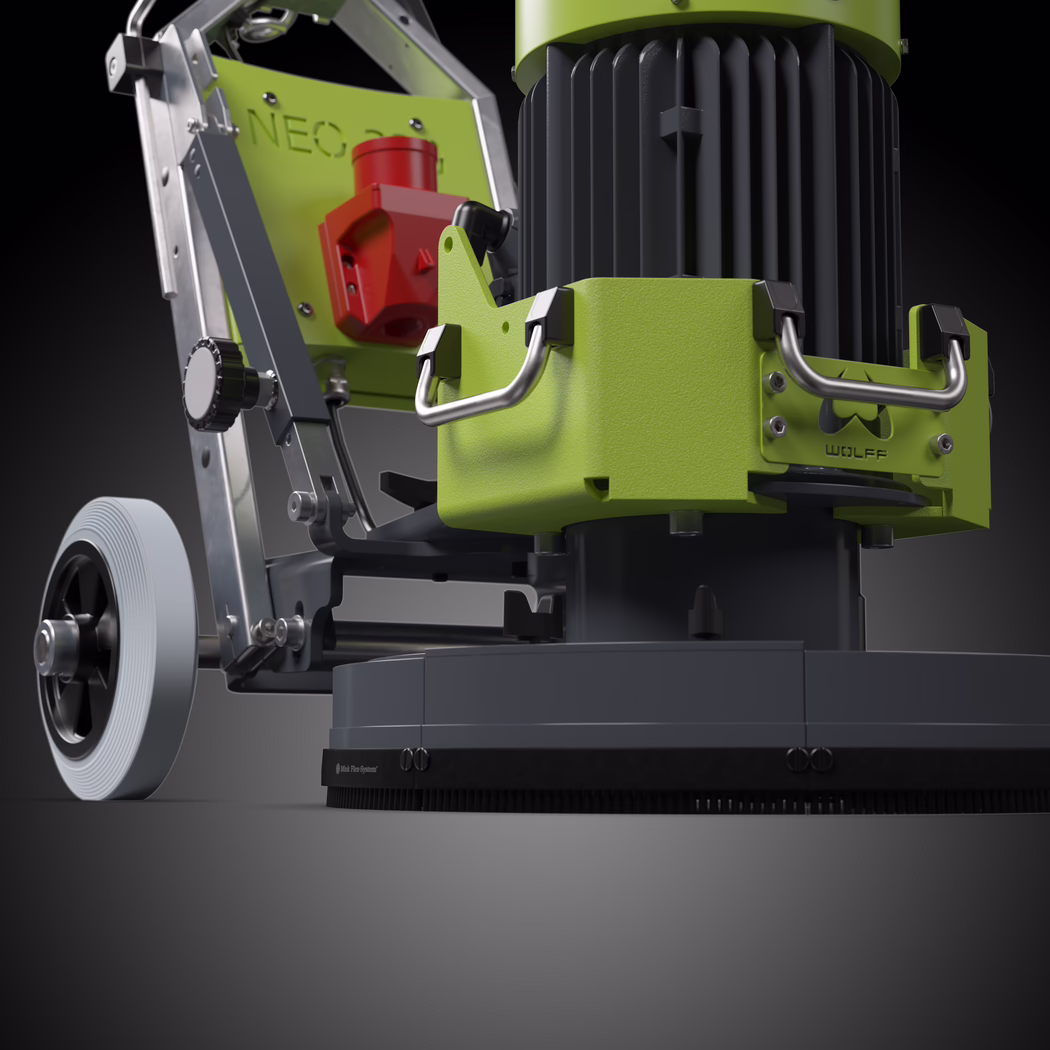 Nahaufnahme einer professionellen Bodenmaschine in kontrastreichem Schwarz-Weiß. Die Komposition konzentriert sich aus niedriger Perspektive auf den unteren Motor und das Bürstengehäuse und betont den gerippten Industrie-Elektromotor, das strukturierte Metallschutzgehäuse mit zwei massiven Edelstahlgriffen sowie die runde Polierbasis mit dichtem Bürstenkragen. Links ist ein großes Vollrad mit konzentrischer Lauffläche sichtbar, das an einem stabilen Aluminiumrahmen mit Verstellknöpfen, Bolzen und Scharnierteilen befestigt ist; auf der Rahmenplatte ist schwach die Prägung "NEO" erkennbar, während an der Gehäuseplatte ein kleines Typenschild mit der Aufschrift "WOLFF" sitzt. Die Beleuchtung kommt von oben und leicht vorn-links und erzeugt scharfe Glanzlichter auf bearbeiteten Metallflächen sowie tiefe Schatten, die Form und Material hervorheben und der Szene eine technische, greifbare Qualität verleihen. Das Bild vermittelt Maßstab, Gewicht und mechanische Details – glatte Gussteile, gebürstete Metallgriffe, gerändeltes Einstellrad, sichtbare Befestigungselemente und gummierte Abschlüsse – geeignet für Produktkataloge oder technische Dokumentation.